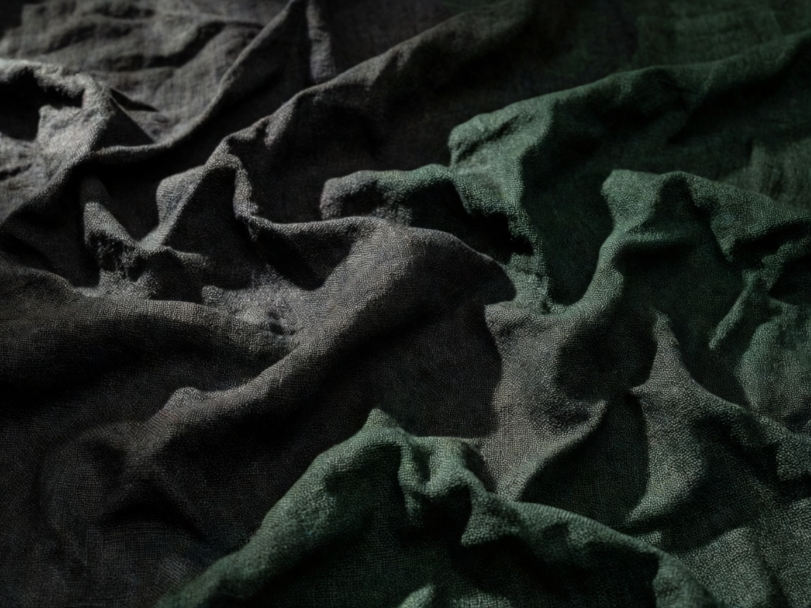 Close up of dark charcoal and deep green linen fabric folds
