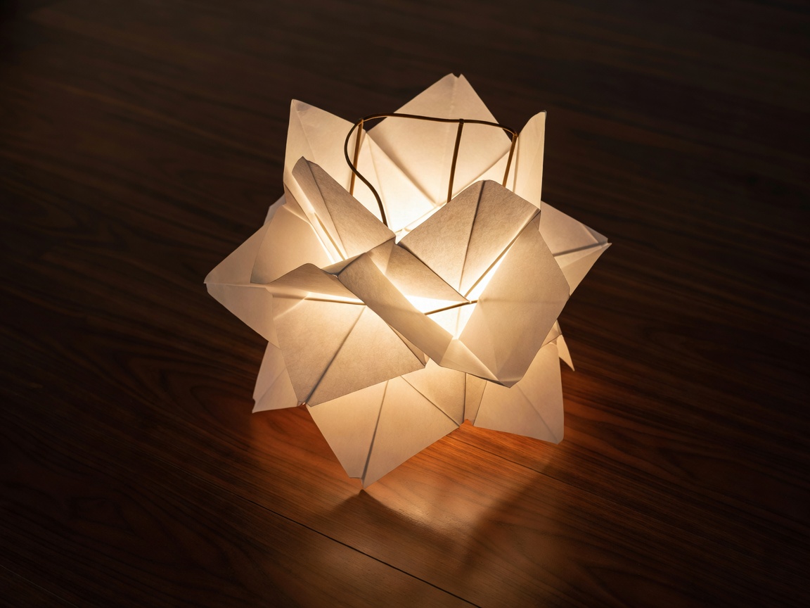 A glowing Noguchi paper lantern resting on a dark walnut floor